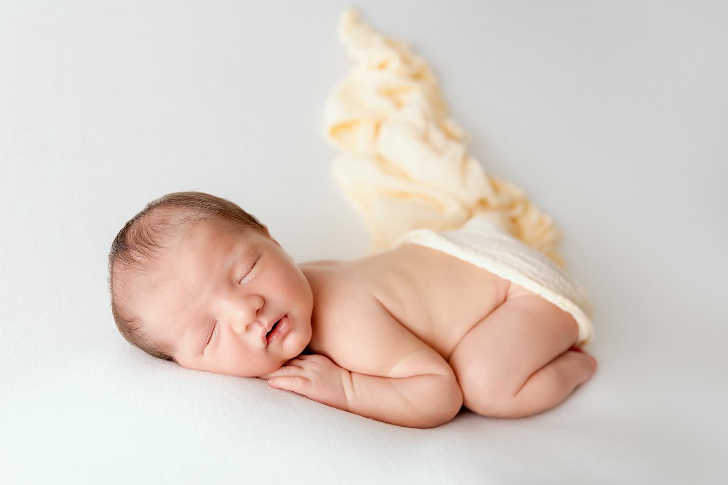 Bébé nouveau-né endormi en pose artistique, photographie professionnelle en studio à Annemasse