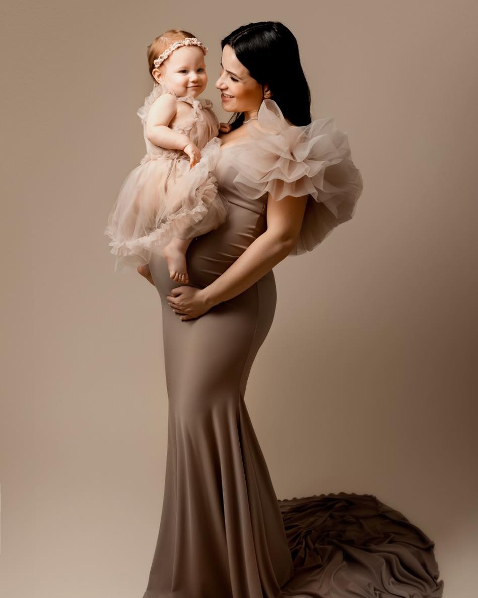 Mère enceinte tenant sa fille en robe tulle rose, photo maternité élégante en studio, photographe famille en Haute-Savoie