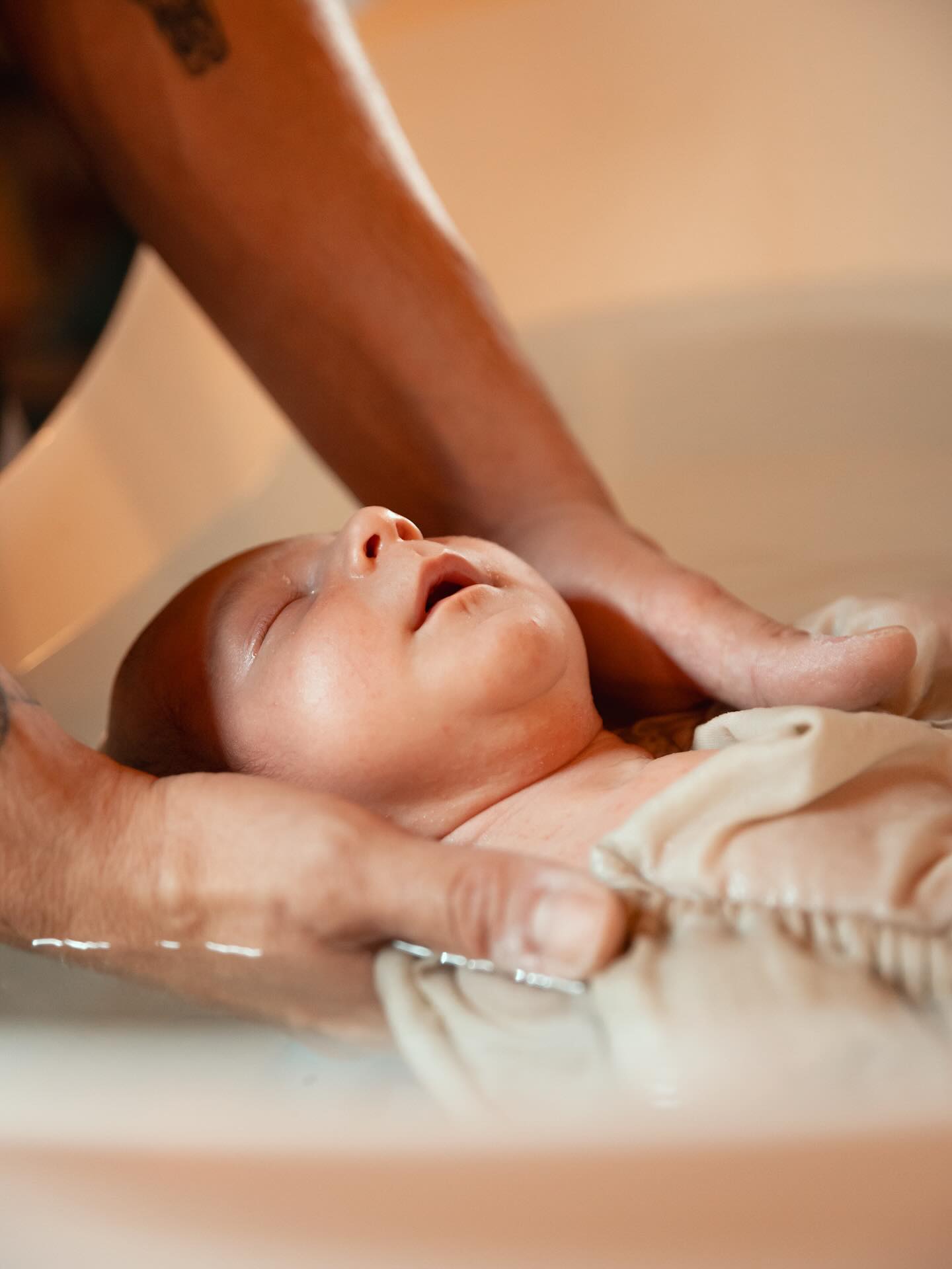 Nouveau-né endormi dans les bras de ses parents, photographie douce et intemporelle en studio