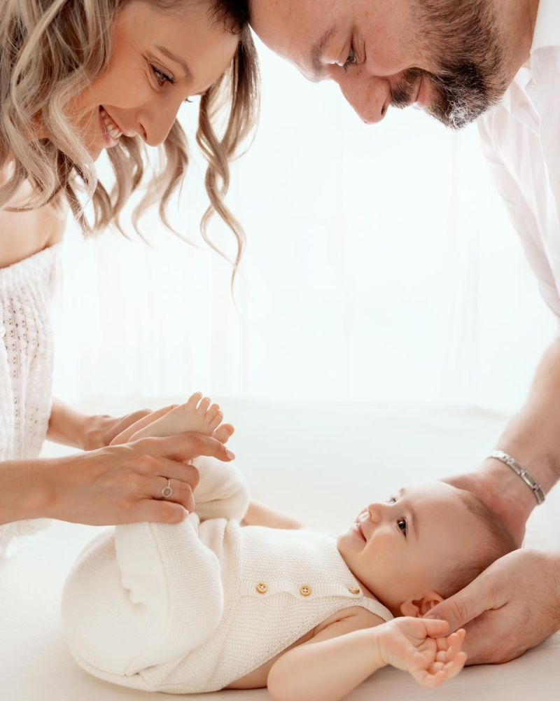 Parents et bébé nouveau-né en séance photo famille intimiste en studio près de Genève