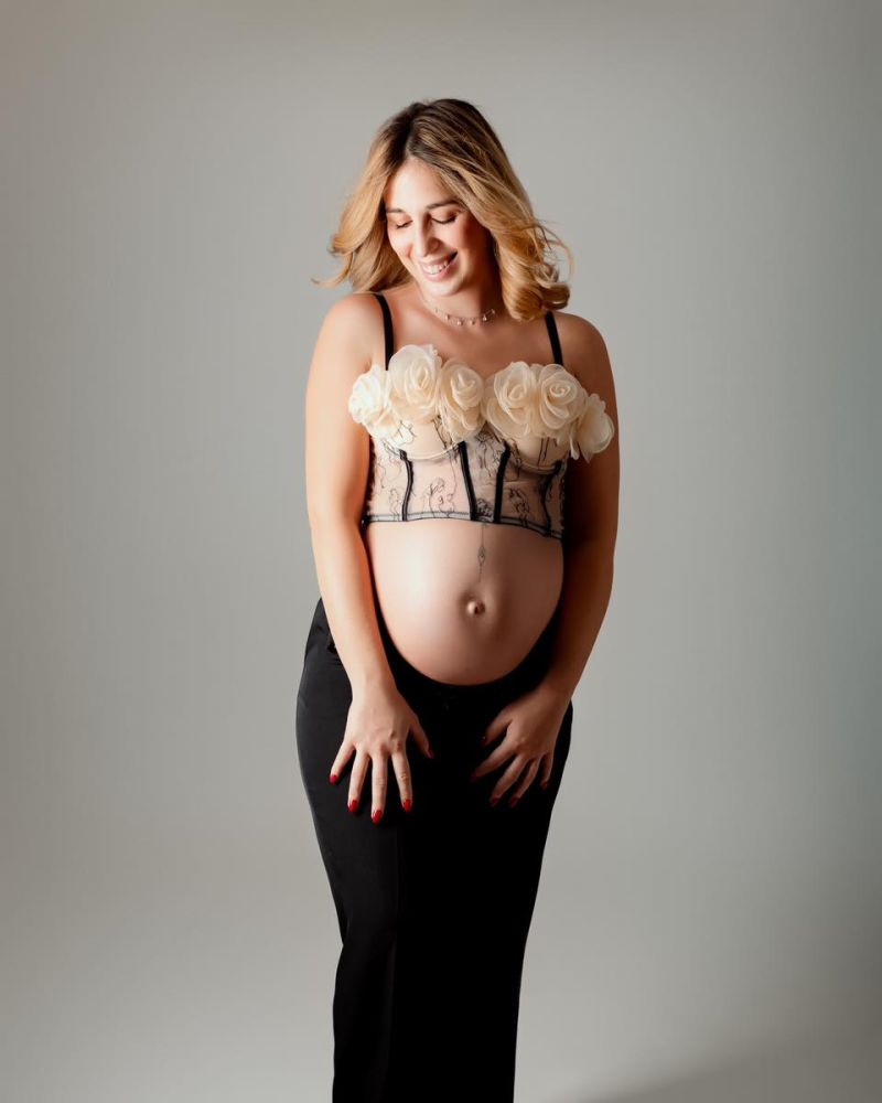 Femme enceinte en séance photo maternité professionnelle avec accessoires floraux, studio photo Haute-Savoie