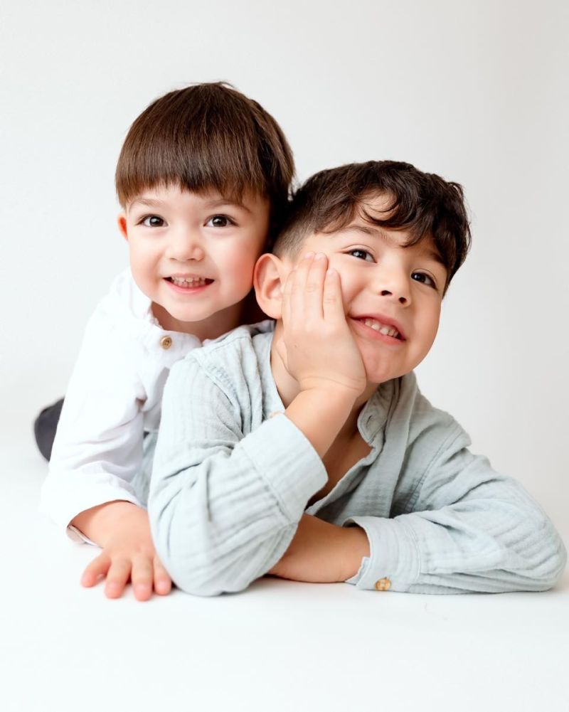 Deux jeunes frères souriants posant ensemble pour un portrait professionnel en studio - Mlle L Photographie Annemasse près de Genève