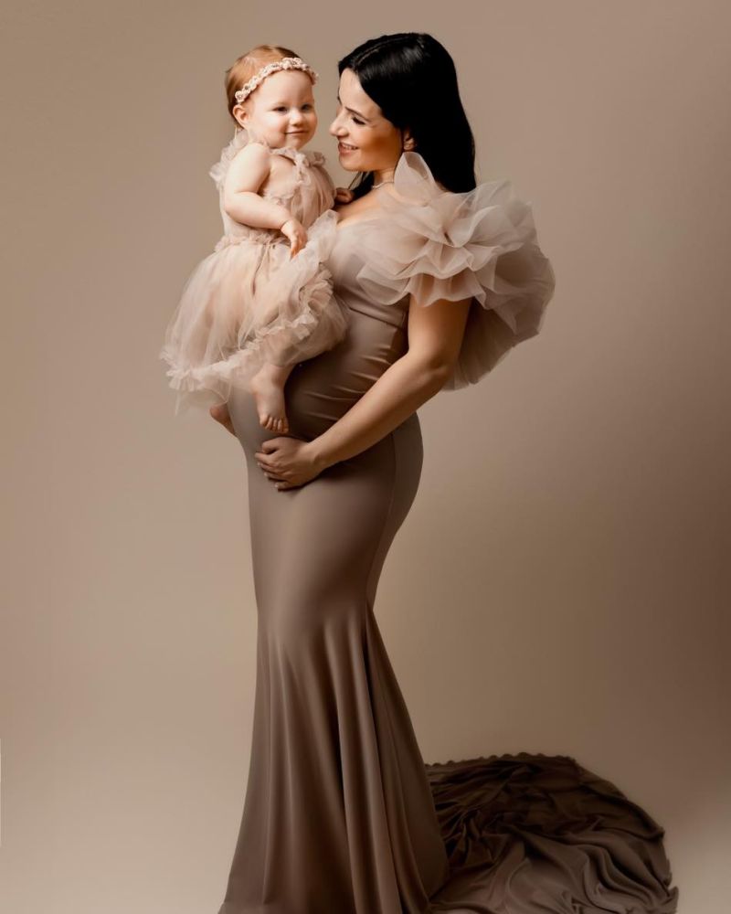 Mère enceinte tenant sa fille en robe tulle rose, photo maternité élégante en studio, photographe famille en Haute-Savoie