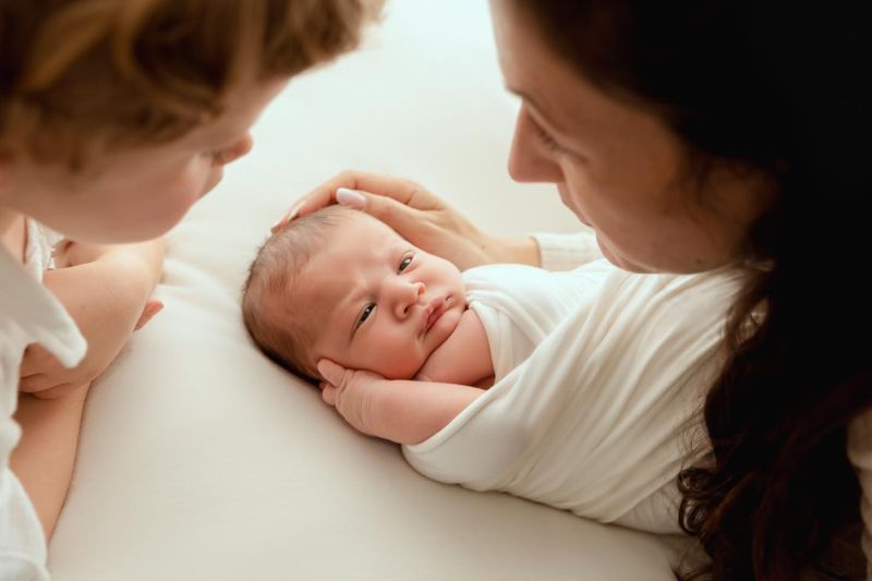 Parents admirant leur nouveau-né, photographie famille tendresse en studio Annemasse près de Genève