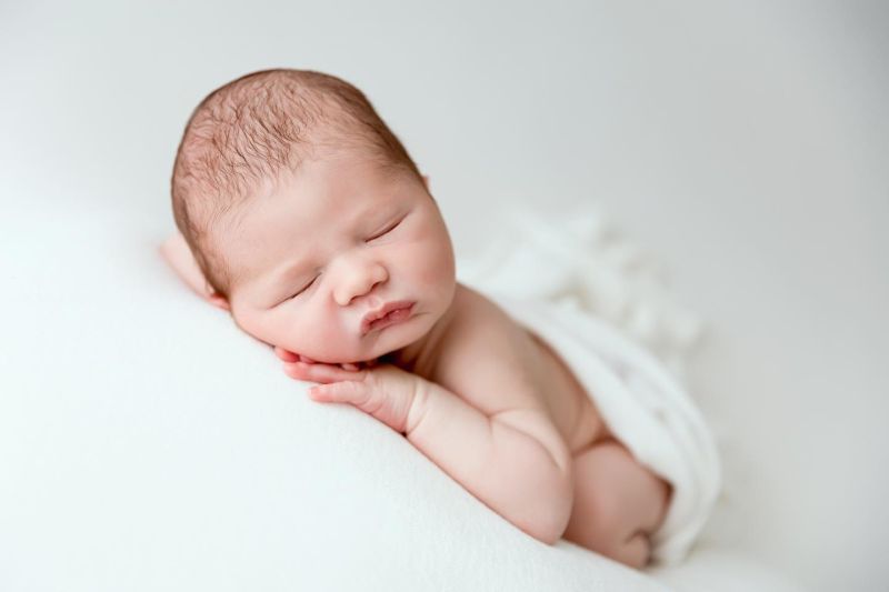 Nouveau-né endormi photographié en studio, portrait délicat d'un bébé nouveau-né, photographe nouveau-né en Haute-Savoie