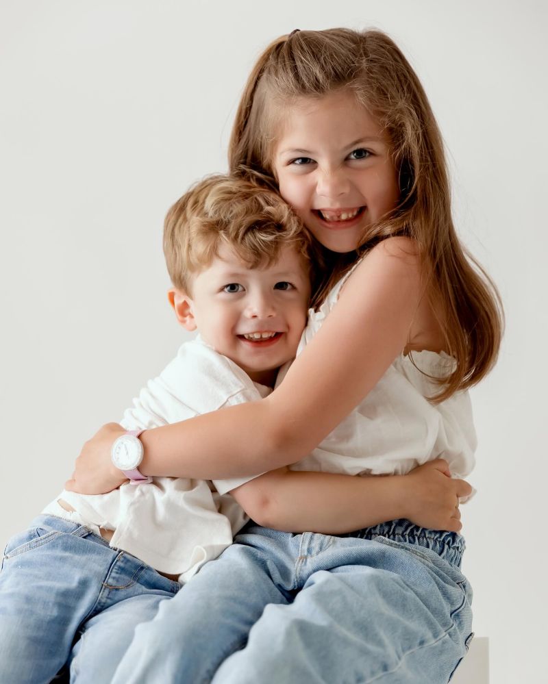 Portrait studio de deux enfants souriants, frère et sœur, photographiés par Mlle L Photographie à Annemasse