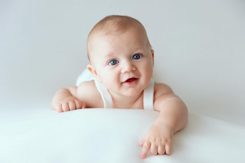 Portrait souriant d'un bébé heureux en studio photo professionnel avec fond neutre, photographe bébé à Annemasse, près de Genève