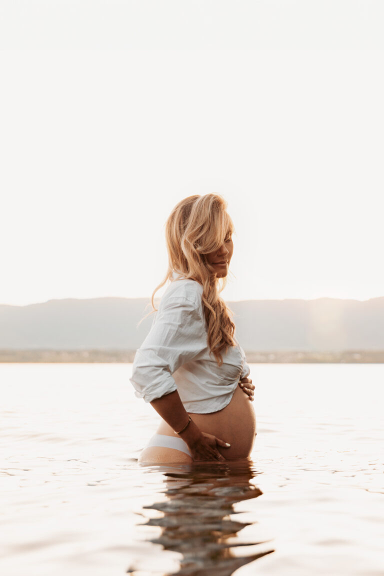 Mum-to-be in a white shirt standing in a lake, outdoor maternity session