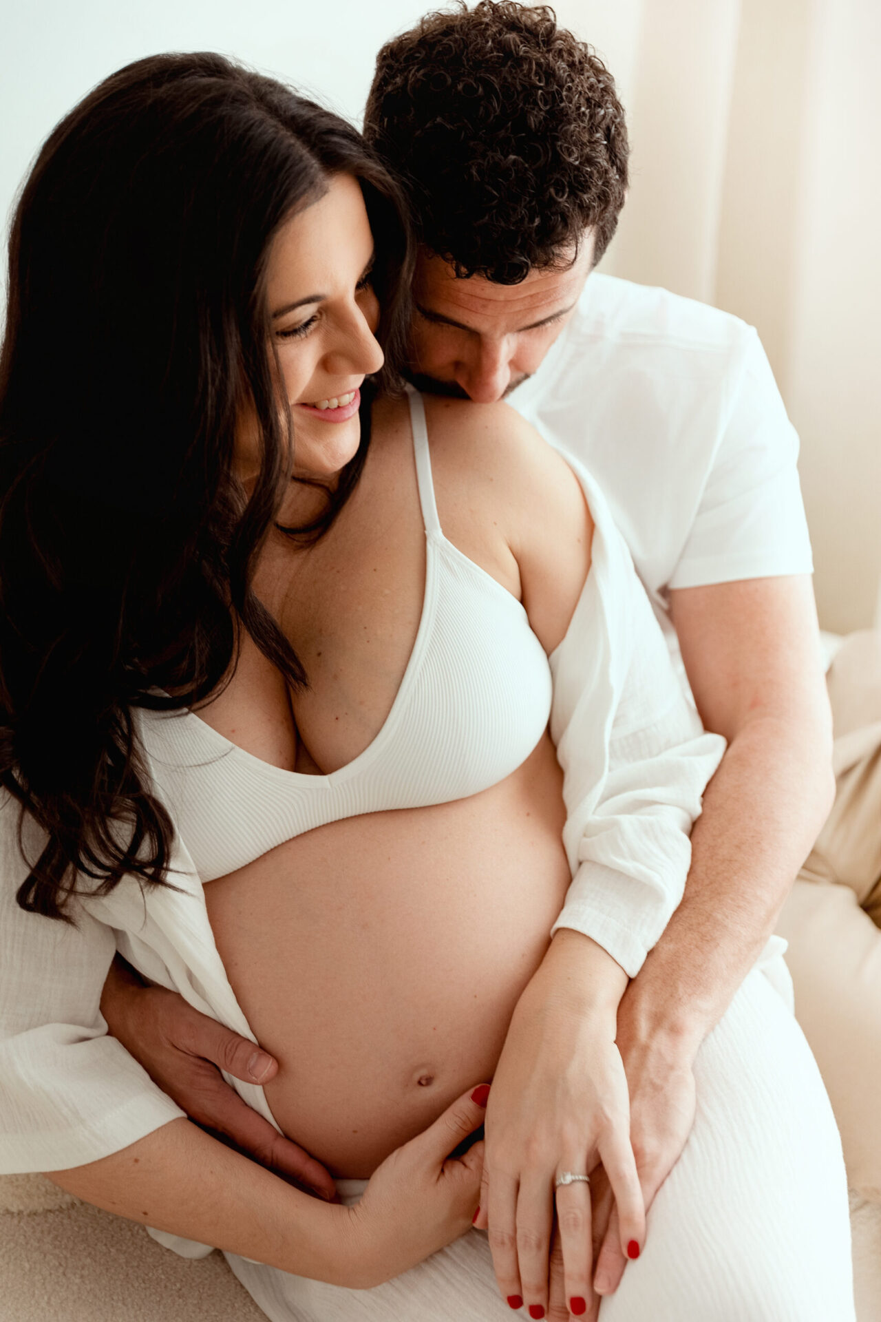 Mlle-L-LAURA-110426-46 Séance photo couple grossesse intimiste en blanc avec futur papa embrassant femme enceinte