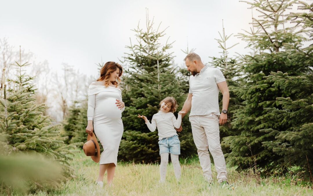 Famille enceinte avec enfant dans champ de sapins, photo de grossesse en nature près d'Annemasse