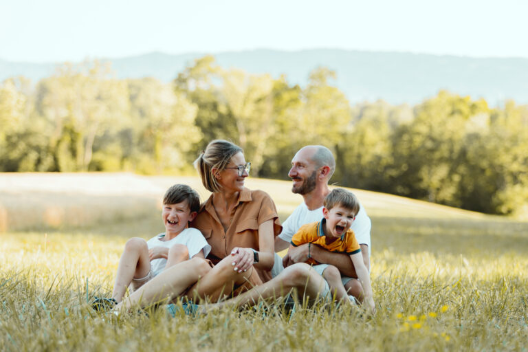Parents and their two boys sitting in the grass, outdoor family session