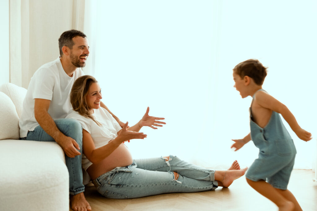 Séance photo famille enceinte et enfant joyeux à Annemasse, femme enceinte souriante avec père et fils jouant ensemble