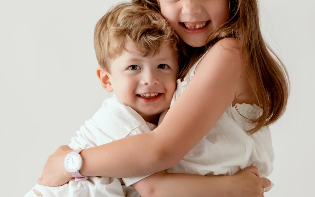Portrait studio de deux enfants souriants, frère et sœur, photographiés par Mlle L Photographie à Annemasse